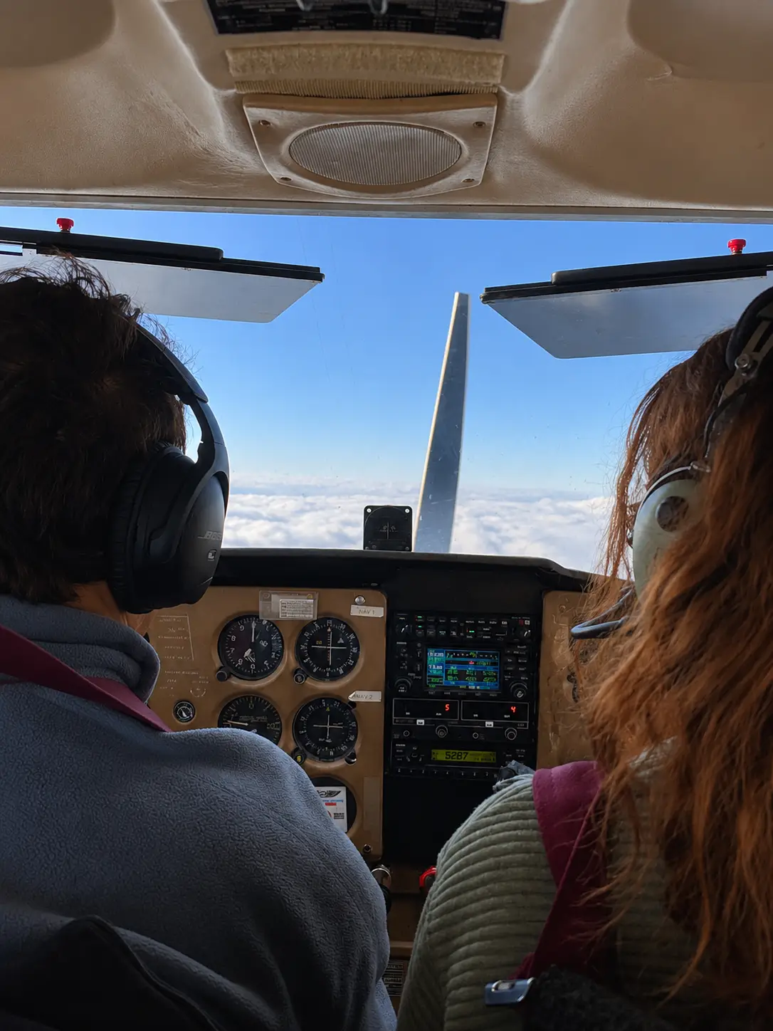Certified flight instructor and student pilot sitting inside the cockpit of a Cessna, checking controls during flight training