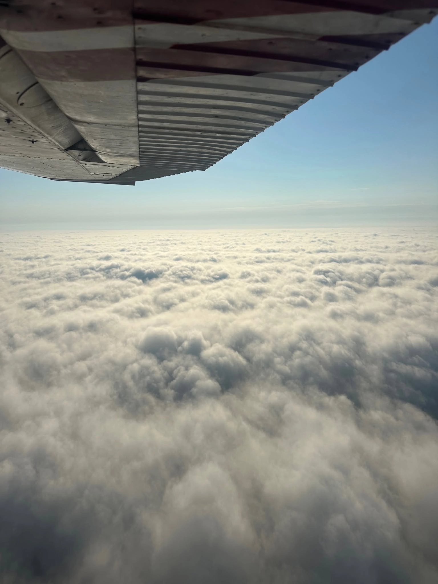View from a cockpit window over the clouds — Triad Aviation Academy flight training
