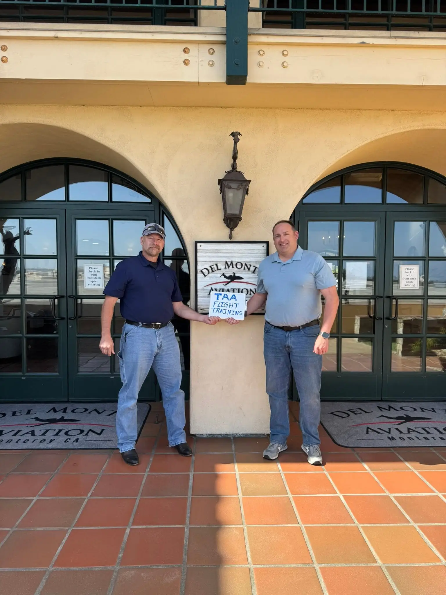 Student pilot and flight instructor with training plaque at Triad Aviation Academy