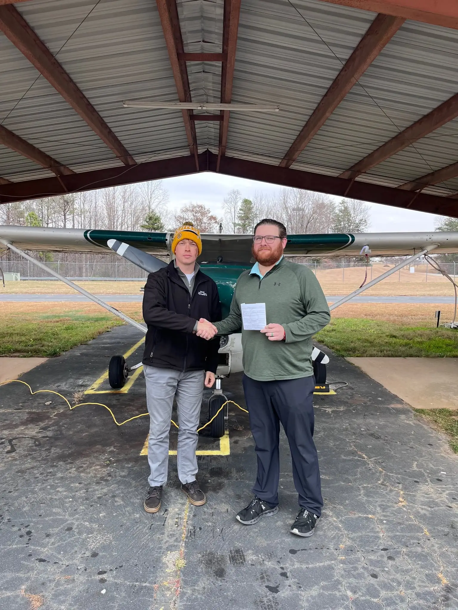 Commercial pilot student shaking hands with flight instructor
