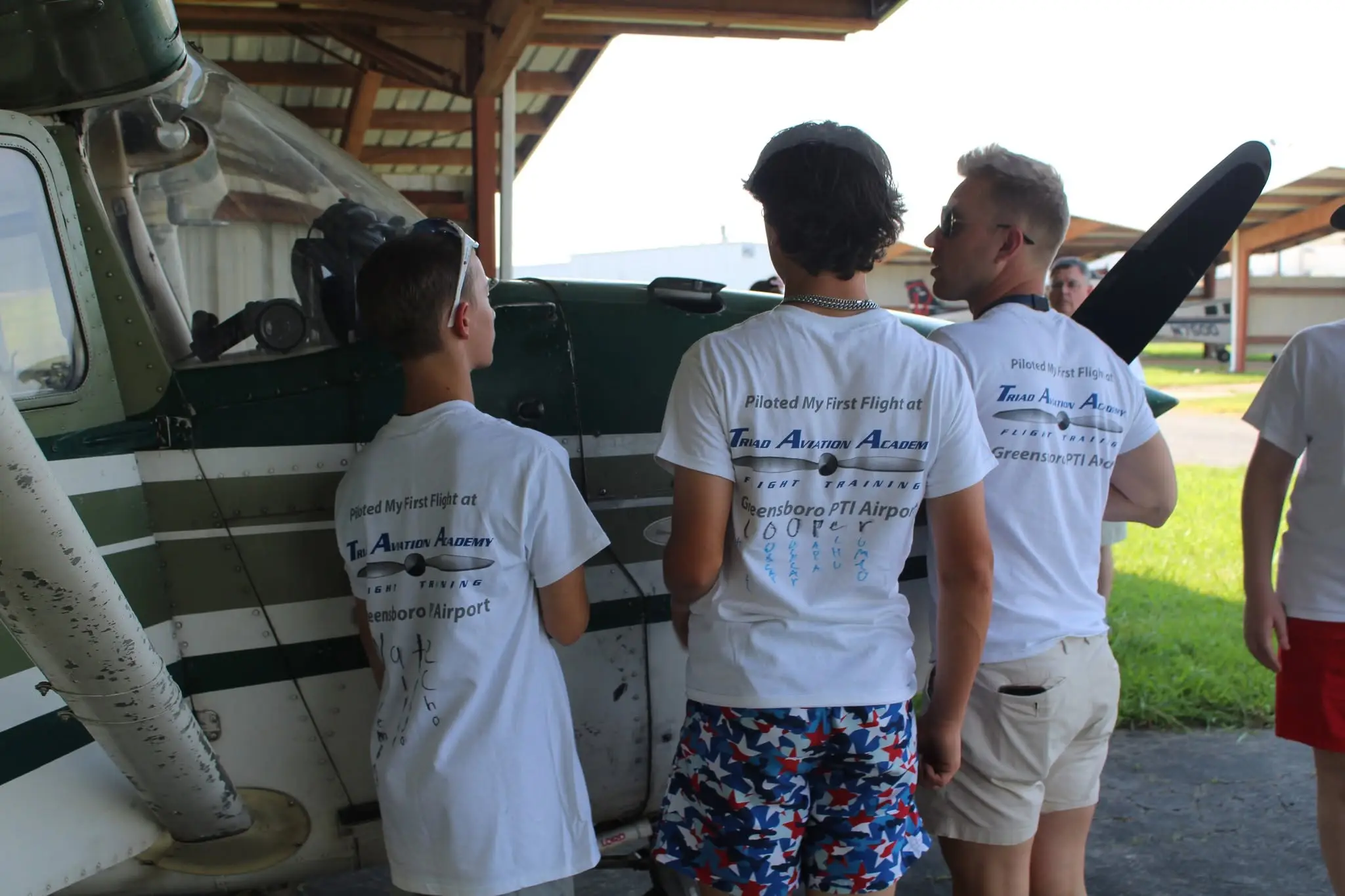 Youth aviation students inspecting aircraft with instructor