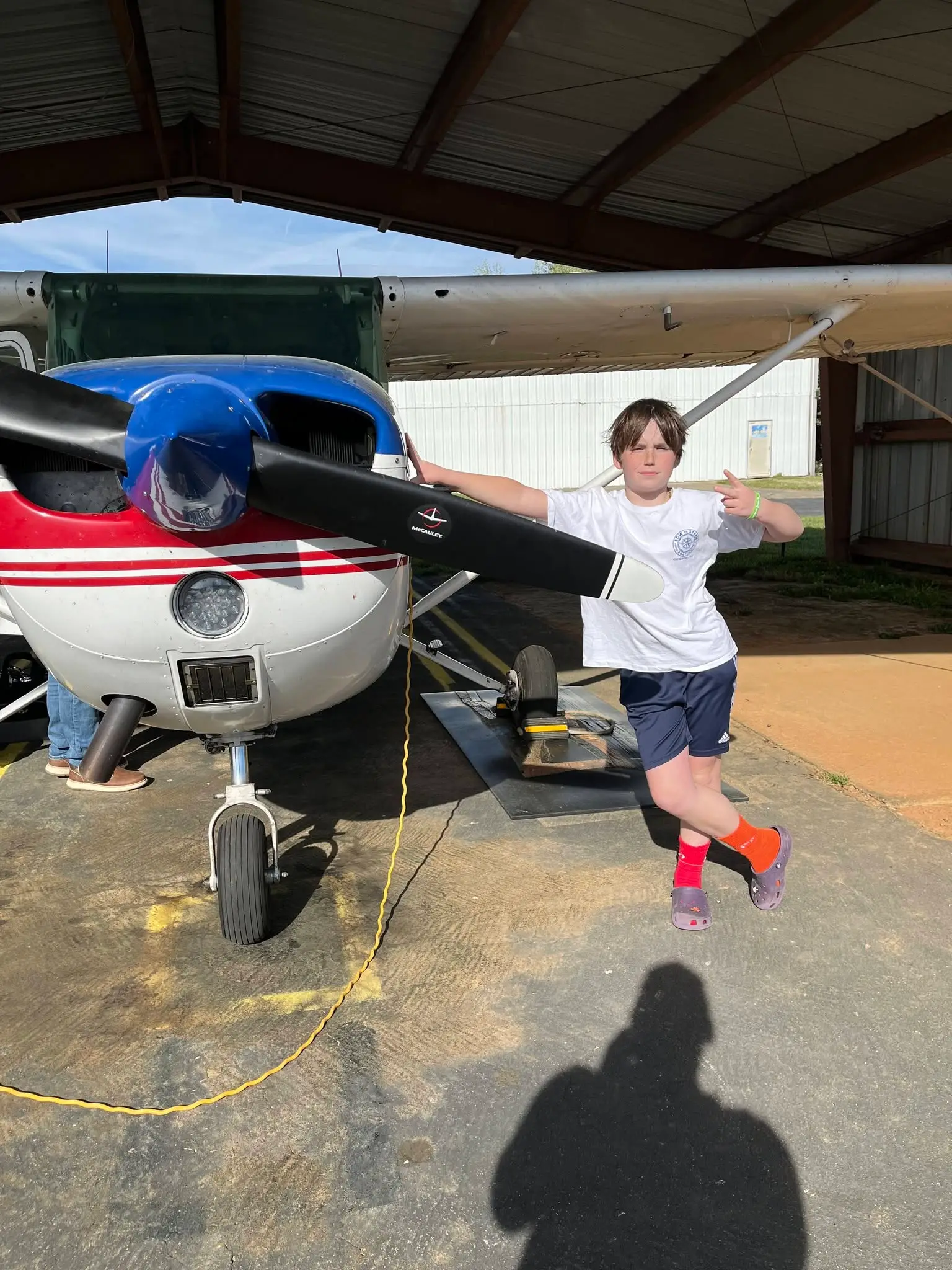 Young pilot standing confidently next to a training Cessna